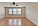 Large bedroom with wood flooring and natural light from the three windows at 702 Village Field Ct, Suwanee, GA 30024
