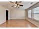 Bright bedroom featuring a ceiling fan, hardwood floors, and plenty of natural light from the windows at 702 Village Field Ct, Suwanee, GA 30024