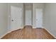 Bedroom featuring three white doors and hardwood style floors at 702 Village Field Ct, Suwanee, GA 30024