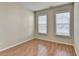 This bedroom offers hardwood floors and lots of natural light from the windows at 702 Village Field Ct, Suwanee, GA 30024