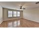 Open bedroom with hardwood floors and a ceiling fan and lots of natural light from the windows at 702 Village Field Ct, Suwanee, GA 30024