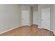 Bedroom features wood floors and white doors with black hardware at 702 Village Field Ct, Suwanee, GA 30024