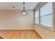 Dining room featuring neutral walls, wood floors, and windows with natural light at 702 Village Field Ct, Suwanee, GA 30024