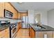 Modern kitchen featuring stainless appliances, granite counters, and a gas range at 702 Village Field Ct, Suwanee, GA 30024