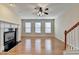 Cozy living room with gleaming hardwood floors, fireplace, and staircase access at 702 Village Field Ct, Suwanee, GA 30024