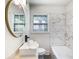 Bright bathroom featuring modern fixtures, a sleek sink, and a tub with stylish marble-look tiled walls at 888 Old Tucker Rd, Stone Mountain, GA 30087