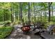 Backyard space with a fire pit circled by Adirondack chairs nestled amongst mature trees and foliage at 1050 Signal Pointe, Alpharetta, GA 30005