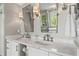 Bathroom featuring marble counters, decorative mirrors, and traditional fixtures at 1050 Signal Pointe, Alpharetta, GA 30005