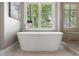 Elegant freestanding bathtub near a window with lush greenery, creating a spa-like feel at 1050 Signal Pointe, Alpharetta, GA 30005