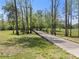 A meandering wooden path stretches through a serene landscape with mature trees and a grassy meadow at 1050 Signal Pointe, Alpharetta, GA 30005