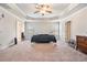 Main bedroom featuring tray ceilings, a ceiling fan, large windows, and plush carpeting at 3780 Casual Ridge Way, Loganville, GA 30052
