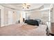 Spacious main bedroom featuring tray ceilings, a ceiling fan, large windows, and plush carpeting at 3780 Casual Ridge Way, Loganville, GA 30052