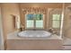 Close up of the tiled jetted tub with window and candles with a walk in shower to the right at 402 Glenhurst Trce, Canton, GA 30115