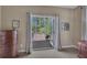 Bedroom with neutral walls, dresser, and an open door to a wooden deck overlooking a wooded area at 402 Glenhurst Trce, Canton, GA 30115