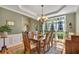 Sunlit dining room with views of the landscaped garden, features a classic wooden table and rug at 402 Glenhurst Trce, Canton, GA 30115
