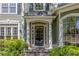 Covered front entrance featuring detailed columns, a black front door, and manicured landscaping at 402 Glenhurst Trce, Canton, GA 30115