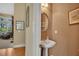 A cozy half bathroom with a pedestal sink, oval mirror, and neutral color scheme offers practicality at 402 Glenhurst Trce, Canton, GA 30115