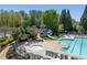View of a community pool with a slide, seating, hot tub, and surrounding landscaping at 402 Glenhurst Trce, Canton, GA 30115