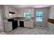 Bright kitchen features ample white cabinetry, black appliances, and sleek vinyl flooring at 4402 Sebring Walk, Decatur, GA 30034