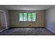 Carpeted living room featuring neutral paint, a large window, and an adjacent entrance at 4402 Sebring Walk, Decatur, GA 30034