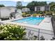 Community swimming pool surrounded by lounge chairs with a garden area along the fence at 1150 Collier Nw Rd # E3, Atlanta, GA 30318
