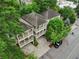 Aerial view of a multi-story home with balconies, mature trees, a driveway, and a parked car at 737 St Charles Ne Ave, Atlanta, GA 30306