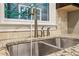 Close-up of a modern kitchen sink with granite countertops and contemporary fixtures under window at 737 St Charles Ne Ave, Atlanta, GA 30306