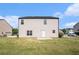 View of the back of the home with a large backyard and lawn at 115 Oakwood Dr, Covington, GA 30016