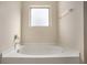 Clean bathroom featuring a soaking tub, frosted window, and modern hardware at 115 Oakwood Dr, Covington, GA 30016