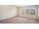 Bright bedroom with three windows offering neighborhood views and neutral carpeting at 115 Oakwood Dr, Covington, GA 30016