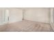 Spacious carpeted bedroom with neutral walls, natural light, and a hallway visible in the background at 115 Oakwood Dr, Covington, GA 30016