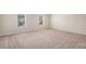 Empty bedroom with neutral walls, carpet, and natural light streaming through the windows at 115 Oakwood Dr, Covington, GA 30016