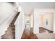 Bright hallway with hardwood floors, a staircase, and an open view into other rooms at 115 Oakwood Dr, Covington, GA 30016