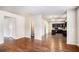 Open-concept living area showcasing hardwood floors, and a glimpse of the kitchen and bathroom at 115 Oakwood Dr, Covington, GA 30016