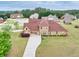 Aerial view of a brick house with a basketball hoop, long driveway, and large lawn at 401 Sara Ct, Loganville, GA 30052