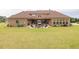 View of backyard, patio with seating, fire pit, and brown brick home at 401 Sara Ct, Loganville, GA 30052