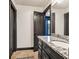 Bathroom features granite countertop on vanity with gray cabinets, tile floors, and framed mirror at 401 Sara Ct, Loganville, GA 30052