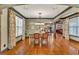 Dining area features hardwood floors, multiple windows, and decorative curtains, with an open view of the kitchen at 401 Sara Ct, Loganville, GA 30052