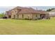 A brick home features a large, well-manicured lawn, covered patio, and attached garage at 401 Sara Ct, Loganville, GA 30052