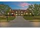 Brick home at dusk with a manicured lawn, symmetrical landscaping, and a long driveway at 401 Sara Ct, Loganville, GA 30052