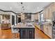 Well-equipped kitchen featuring a large island with sink, custom cabinetry, hardwood floors, and modern appliances at 401 Sara Ct, Loganville, GA 30052