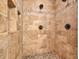 Walk-in shower featuring mosaic tile accents, neutral stone walls, and sleek bronze hardware at 401 Sara Ct, Loganville, GA 30052