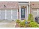 Welcoming townhome entrance with brick accents, garage, and lush landscaping creating an inviting curb appeal at 6304 Brookwater Vw, Mableton, GA 30126