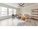 Bright living room featuring large windows, a modern ceiling fan, and stylish furniture creating a cozy atmosphere at 6304 Brookwater Vw, Mableton, GA 30126
