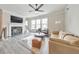 Open-concept living area with a fireplace, large windows, modern ceiling fan, and stylish furniture for comfort at 6304 Brookwater Vw, Mableton, GA 30126