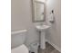Bright powder room featuring a pedestal sink, framed mirror, and tiled floor at 6304 Brookwater Vw, Mableton, GA 30126
