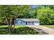 Quaint blue house with a one-car garage, framed by mature trees and lush greenery at 685 Greenhedge Dr, Stone Mountain, GA 30088