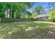 Spacious backyard enclosed by a wooden fence, lush trees, and a deck connected to the house at 1659 Beecher Sw St, Atlanta, GA 30310