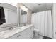 Bright bathroom featuring a double sink vanity, marble countertops, and a shower with white curtain at 1659 Beecher Sw St, Atlanta, GA 30310