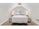 Comfortable bedroom with a sloped ceiling, a queen-sized bed, hardwood floors, and neutral decor at 1659 Beecher Sw St, Atlanta, GA 30310